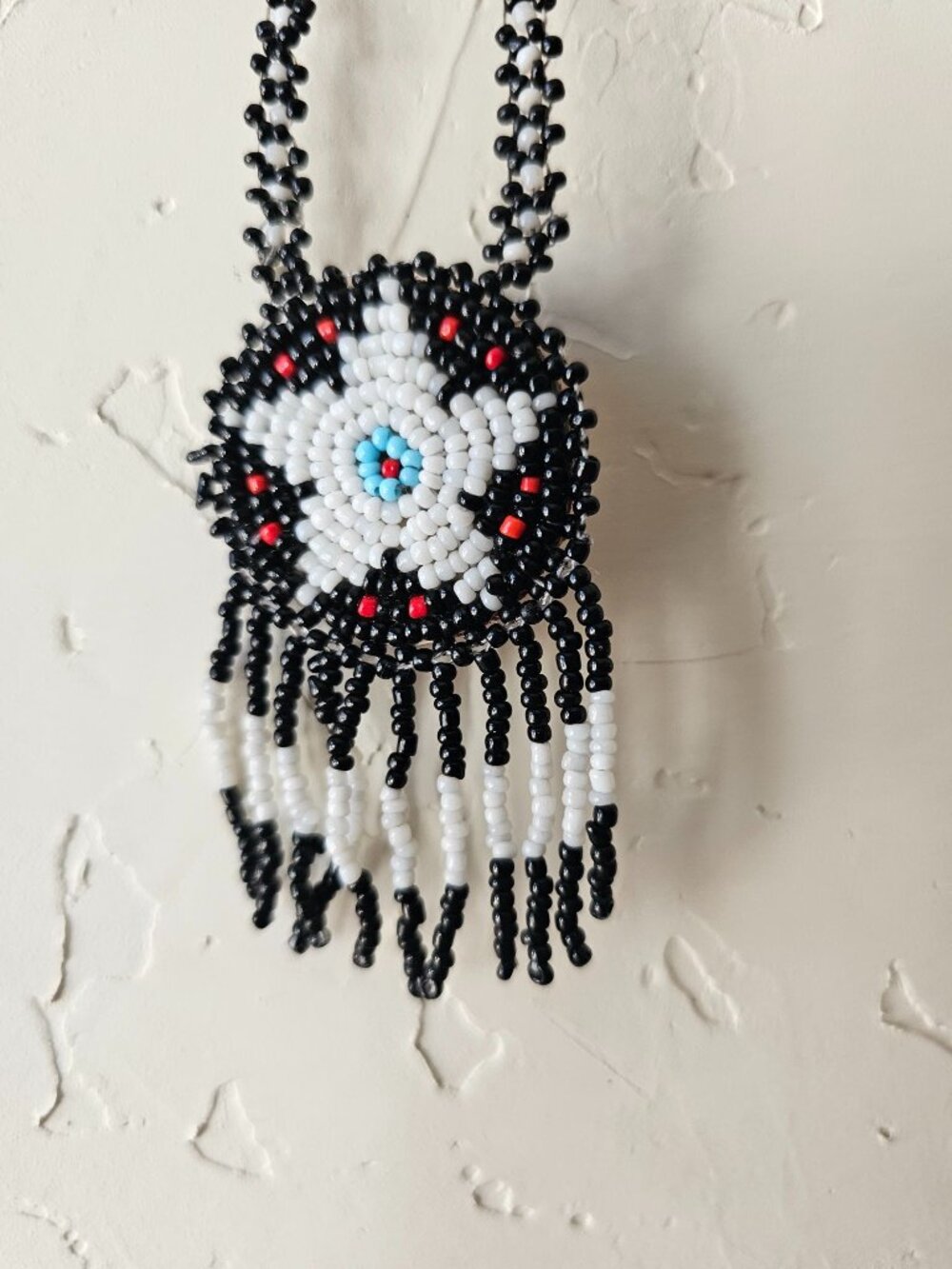 Beaded Necklace With Black White Red & Blue Floral Pendant And Fringe Detailing